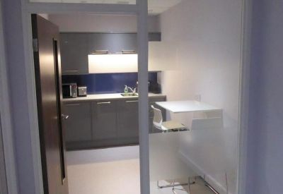 Modern communal kitchen and breakout area with glass partitions.