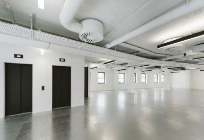 Modern lobby area with black elevator doors and polished grey floors.
