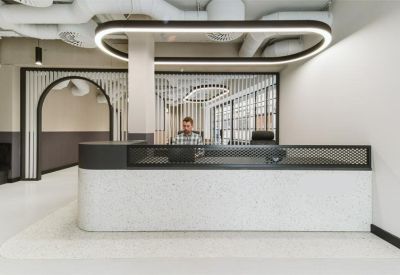 Reception area with a white stone desk under a large halo light fixture.