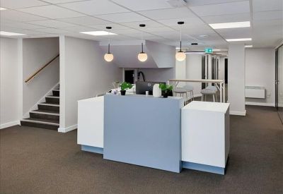 Modern reception desk with a blue feature panel and glass pendant lights.