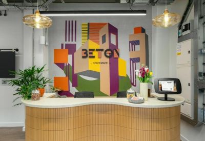 Curved wooden reception desk backed by a vibrant urban-themed mural and warm pendant lights.