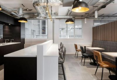 Contemporary breakout space and kitchen with black cabinetry and pendant lighting.