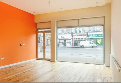 Bright workspace featuring a vibrant orange accent wall and light wood flooring.