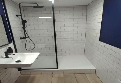 Modern bathroom with white subway tiles, wood-style flooring, and a walk-in shower.