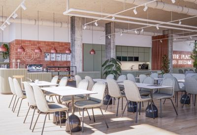 Bright cafeteria and dining area with rows of modern tables, light-colored chairs, and a red brick feature wall.