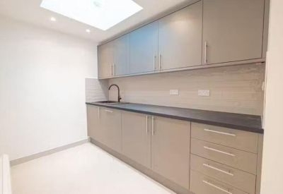 Modern communal kitchenette featuring sleek grey cabinetry and a skylight.