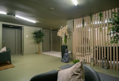 Zen-inspired breakout area with a Buddha statue and slatted wood partition.