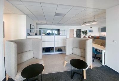 Breakout area featuring high-backed privacy sofas and black coffee tables.