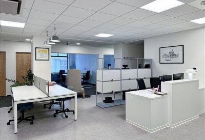 Reception area with a white front desk and modular storage units.