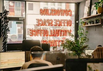 Window signage for coworking and virtual office space with bright red lettering.