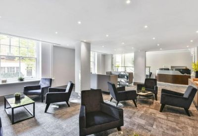 Modern lobby area with plush charcoal armchairs and patterned hardwood flooring.