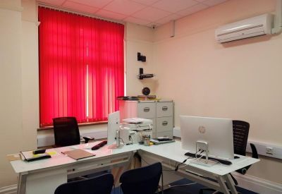 Bright private office with red blinds and modern white desks.