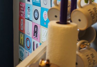 Breakout area detail showing a colorful graphic wall and coffee mugs on a stand.