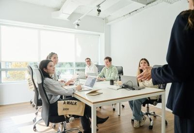Bright meeting room with a large white table and professional team collaborating.