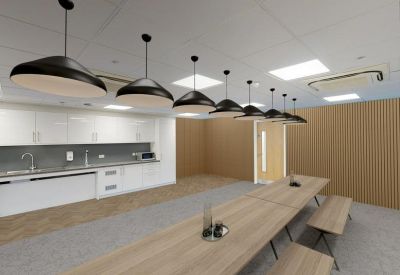 Modern communal kitchen and dining area with long wooden tables and black pendant lamps.