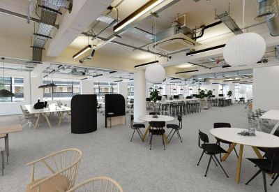 Spacious open-plan workspace featuring industrial ceilings and round white pendant lights.