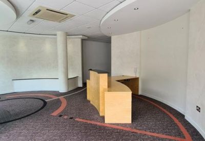 Reception area with a curved wooden desk and circular floor patterns.