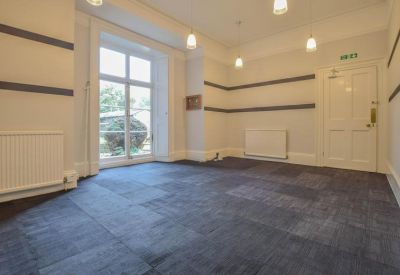 Large meeting room with striped wall details and blue carpet tiles.