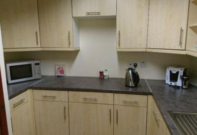 Shared kitchen area with light wood cabinetry and modern appliances.