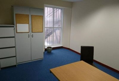 Small meeting room with blue carpeting, a storage cabinet, and a window.