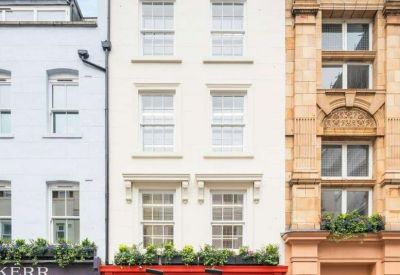 Exterior view of the white brick building at 30 Berwick Street with classic windows and red storefront.