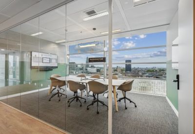 Bright glass-walled conference room with views of the London skyline and a modern display screen.
