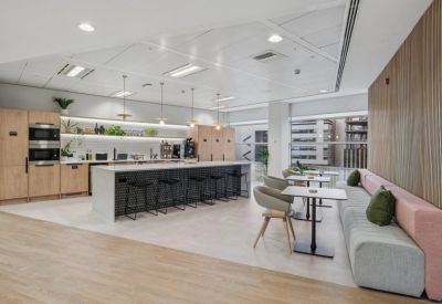 Modern kitchen and breakout area with a tiled island, bar stools, and soft seating.