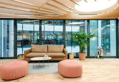 Bright seating area with a tan leather sofa and floor-to-ceiling glass windows.