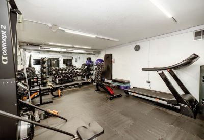 Private gym facility with treadmills, rowing machines, and free weights.