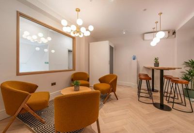 Lounge area with mustard velvet armchairs, a wooden coffee table, and globe pendant lighting.