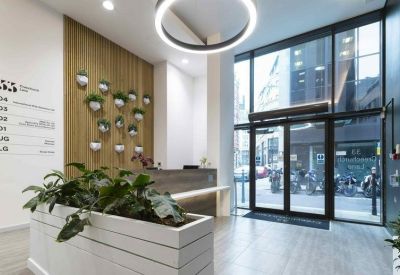 Bright building entrance with a wood-paneled feature wall and glass doors.