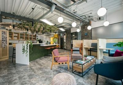 Reception and cafe area with a green tiled counter, hanging plants, and spherical pendant lights.
