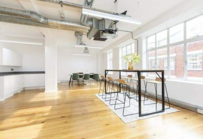 Communal break area featuring a high breakfast bar, stools, and large windows.