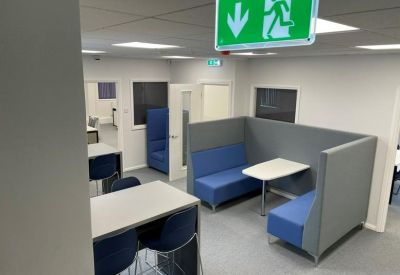 Collaborative workspace with blue high-back sofas and a small meeting table.