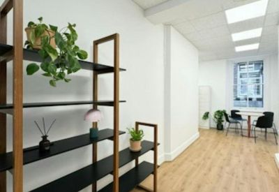 Modern corridor featuring open shelving with plants and a view into a bright seating area.