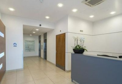Modern reception area with a dark grey desk and wooden wall accents.