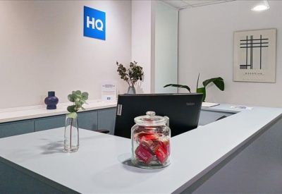 Close-up of a reception counter with a glass candy jar and monitor.