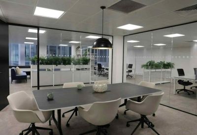 Modern meeting room with a dark table, white swivel chairs, and glass walls.
