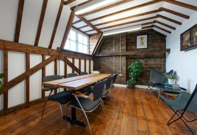 Traditional meeting room with timber framing, exposed brick, and a long wooden table.