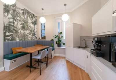 Modern kitchen and dining area featuring a tropical leaf mural and breakfast booth.