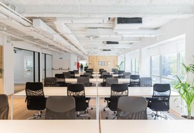 Open-plan workspace with numerous desks and chairs.