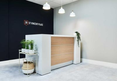 Modern reception area with a wood-panelled desk and branded black feature wall.