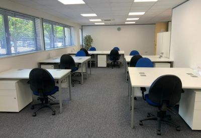 Open-plan office space with organized desks and blue task chairs.