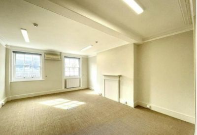 Spacious private office with period features, fireplace, and large windows.
