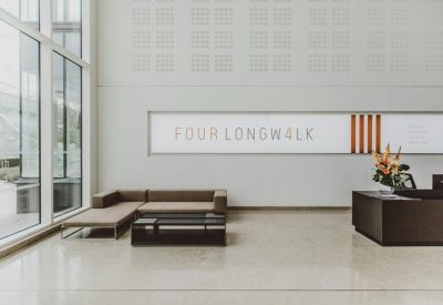 Spacious building lobby featuring a minimalist reception desk and seating area.