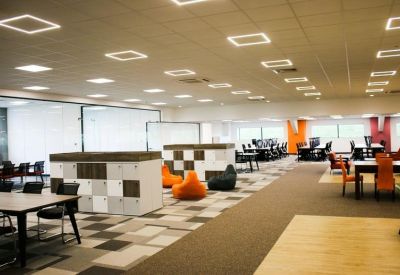 Open-plan coworking space with orange bean bags and locker storage.