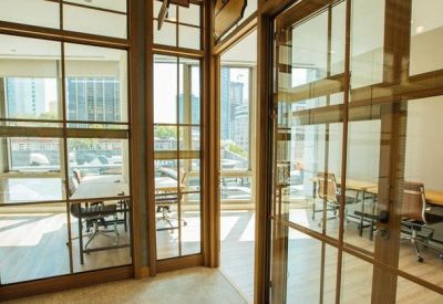Shared workspace divided by glass partitions with views of the city skyline.