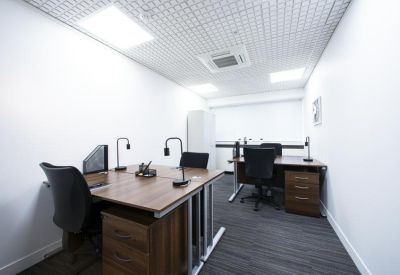 Private office suite with two wooden desks and ergonomic chairs under a drop ceiling.
