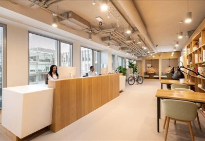 Bright reception area featuring a light wood desk and a corridor leading to workspaces.