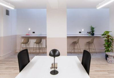 Shared workspace with a white desk and individual wall-mounted stations.